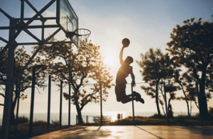 hombre negro haciendo deporte jugando baloncesto al amanecer saltando silueta scaled 2